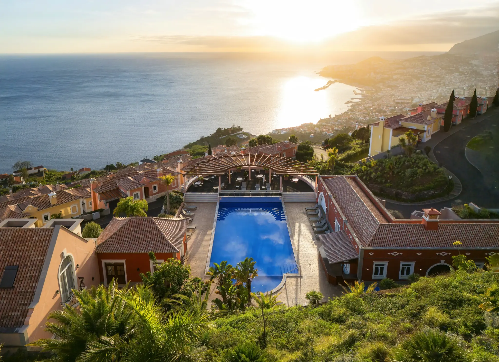 Palheiro Village Madeira — Vista Aérea ao Pôr do Sol com Piscina e Funchal